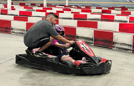 A man assisting a person in a go-kart, highlighting Integra's inclusive events.